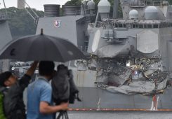 TOPSHOT - A TV crew films the damages on the guided missile destroyer USS Fitzgerald at its mother port in Yokosuka, southwest of Tokyo on June 18, 2017. A number of missing American sailors have been found dead in flooded areas of a destroyer that collided with a container ship off Japan's coast, the US Navy said on June 18, 2017. / AFP PHOTO / Kazuhiro NOGI (Photo credit should read KAZUHIRO NOGI/AFP via Getty Images)