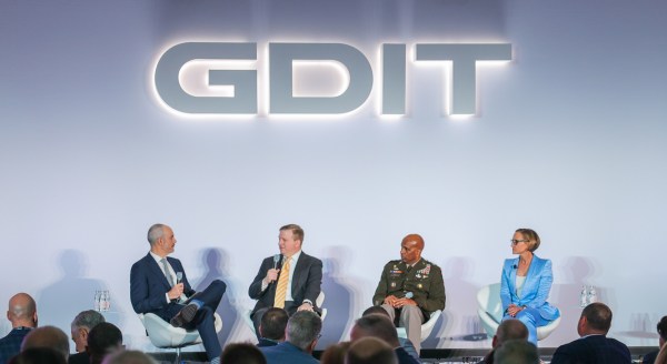 Image of executives speaking on stage at an event.